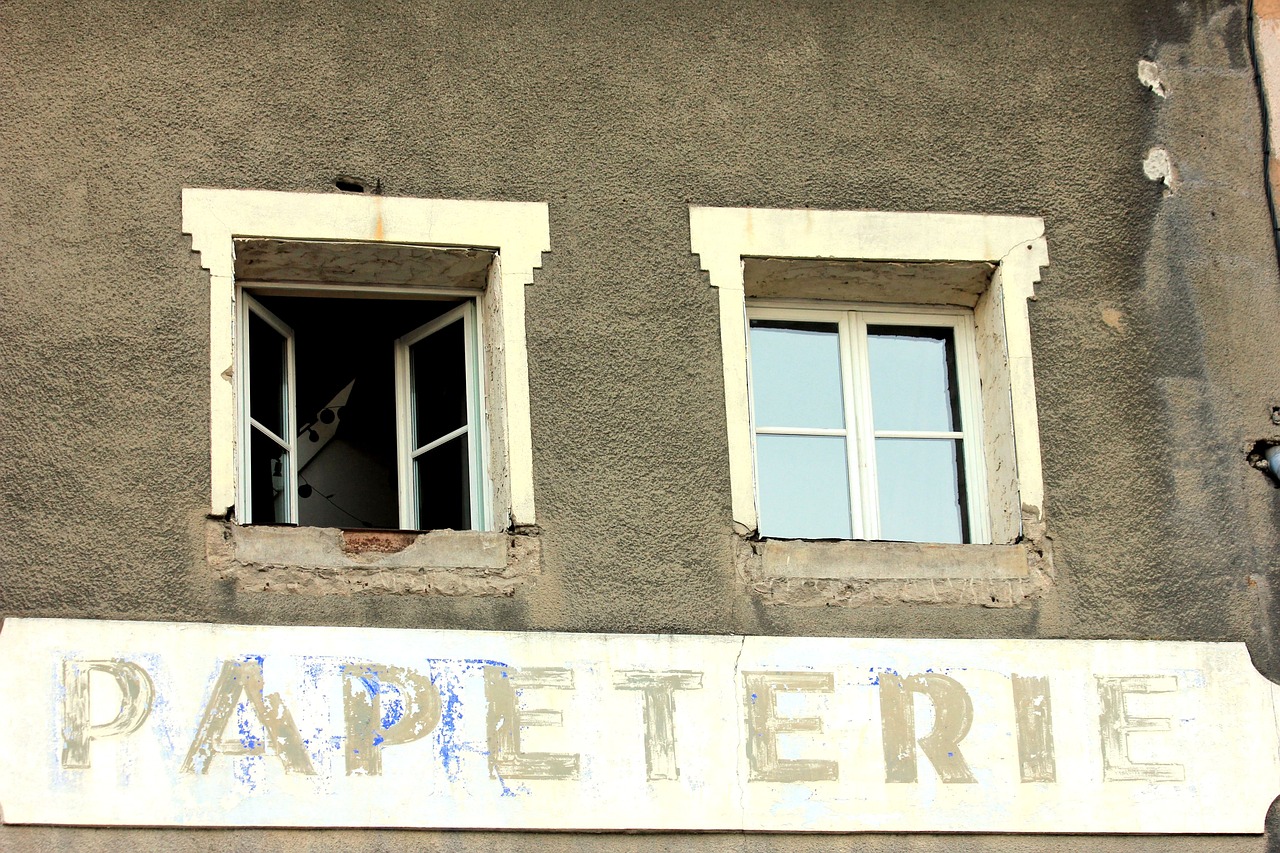 Ancienne enseigne de papeterie sur une façade défraîchie