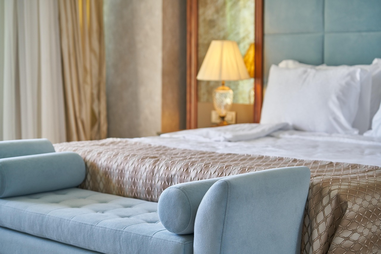 Classic hotel room, made bed and bench at the foot of the bed