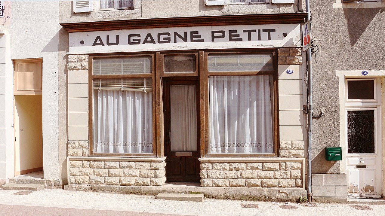 Devanture d'un ancien commerce au rez-de-chaussée d'un immeuble de bourg