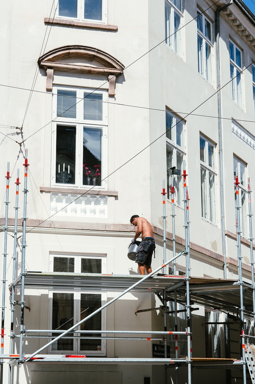 Ouvrier sur un échafaudage devant la façade d’un immeuble ancien