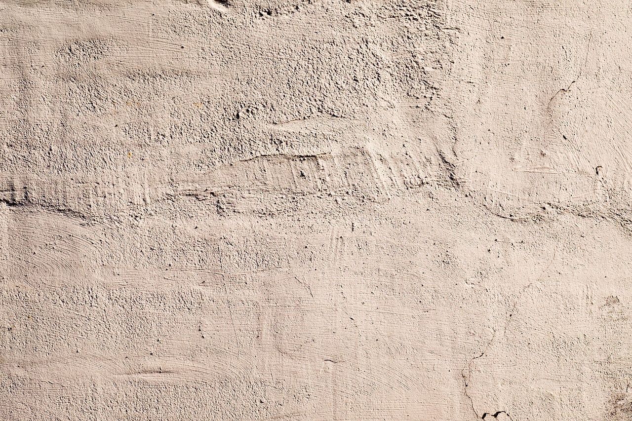 mur enduit à la truelle, avec des traces de rebouchage et de fines fissures