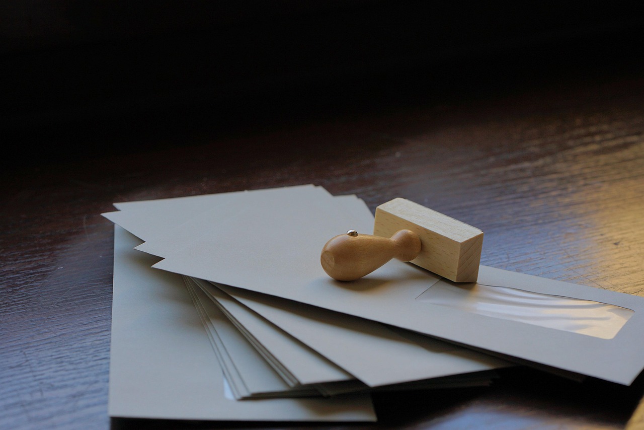 Enveloppes empilées et tampon encreur sur un bureau en bois