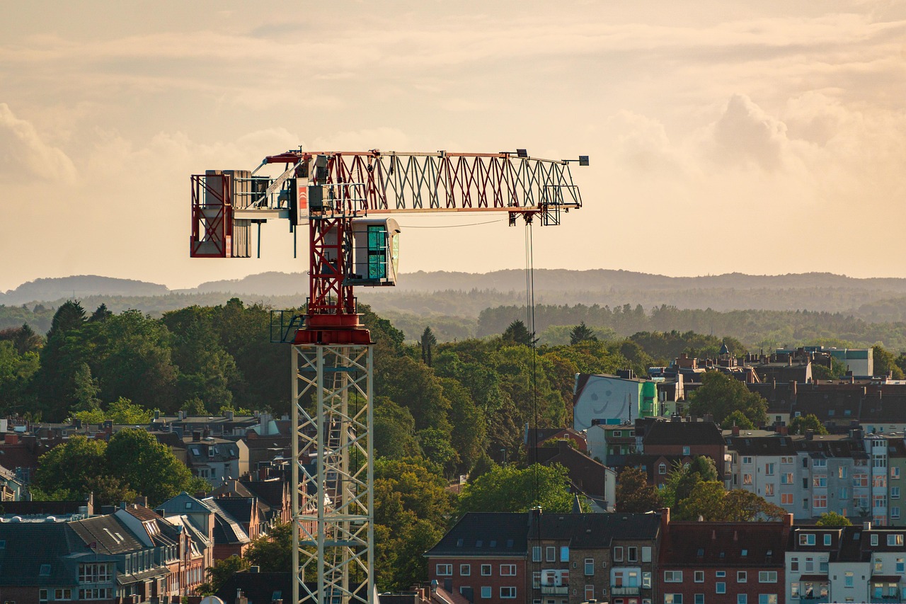 Grue de chantier dressée au-dessus des toits d'un quartier de maisons