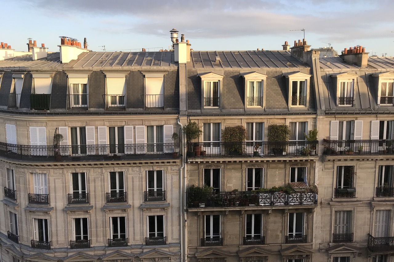 Haussmann-style apartment buildings with a mansard top floor of dormer windows under zinc roofs