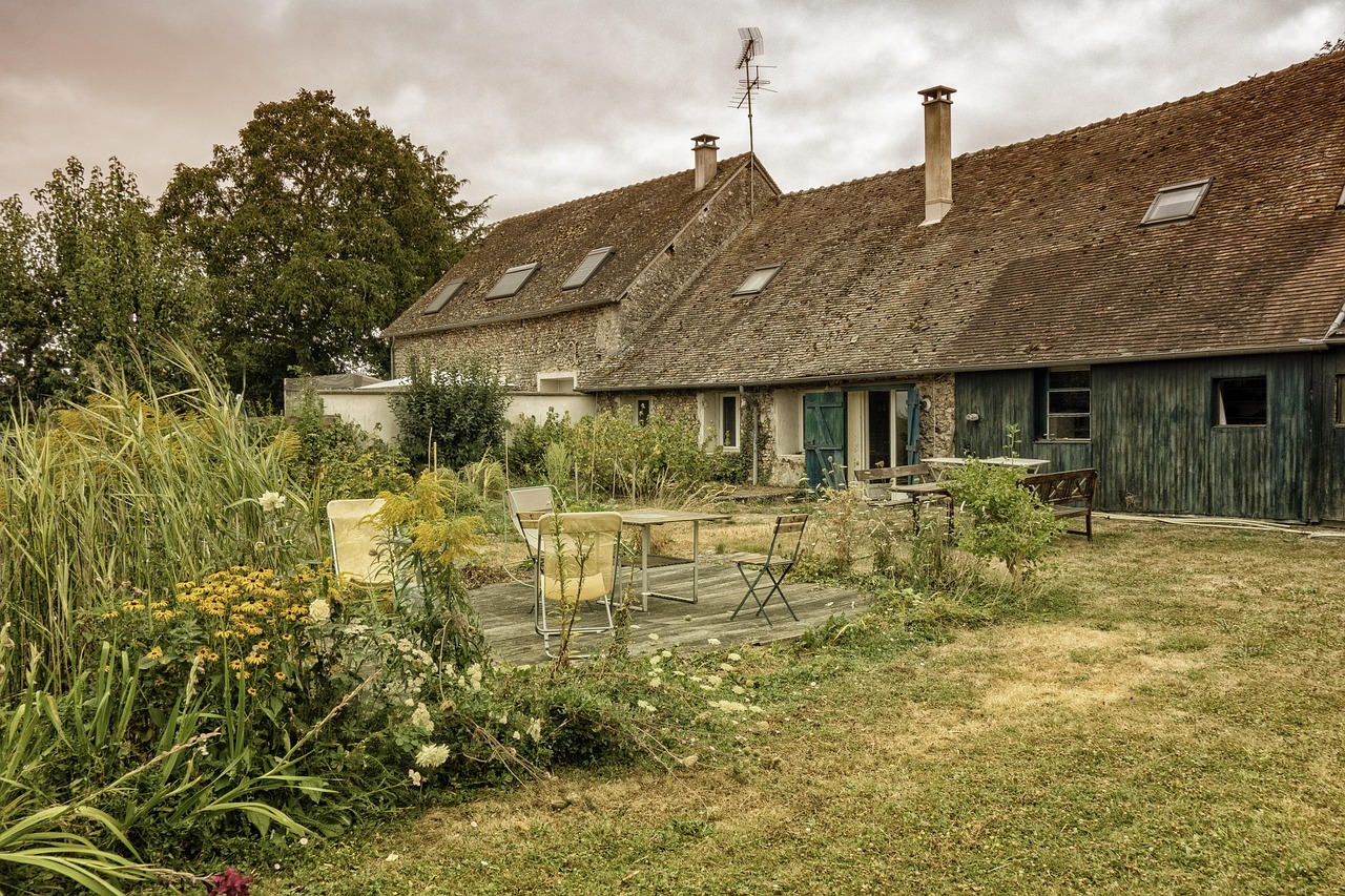 Longère en pierre avec sa terrasse et son jardin en fin d'été