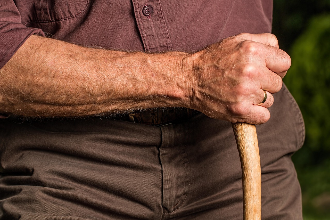 Main d'une personne âgée posée sur le pommeau d'une canne