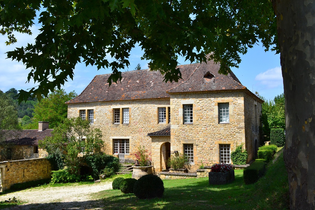 Maison en pierre blonde du Périgord, son jardin et ses buis taillés